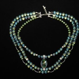Three-strand beaded necklace with green and blue iridescent beads, and an oval-shaped green pendant - Perles Custom Jewelry NYC.”
