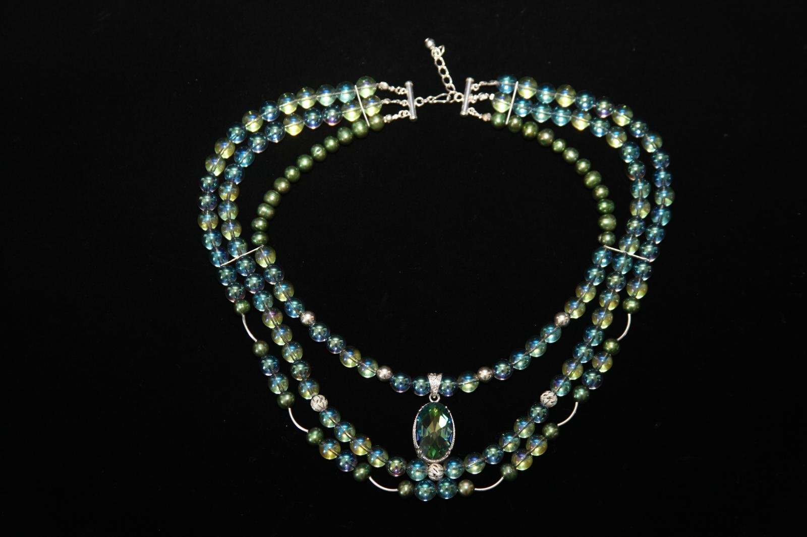 Three-strand beaded necklace with green and blue iridescent beads, and an oval-shaped green pendant - Perles Custom Jewelry NYC.”