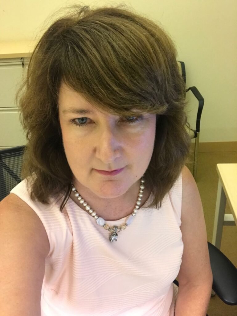 Perles jewelry website owner in New York, smiling slightly, wearing her own pearl necklace - Perles Cusrom Jewelry NYC